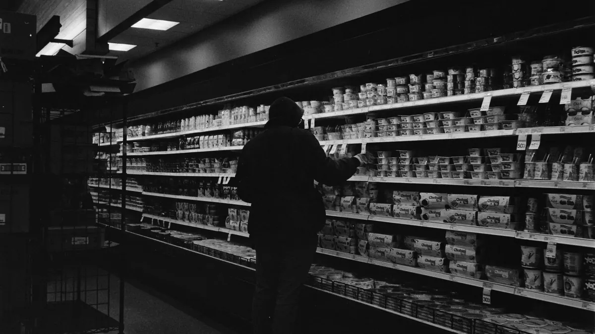 Silueta de una persona ante un lineal de supermercado, escena de un hurto en establecimiento