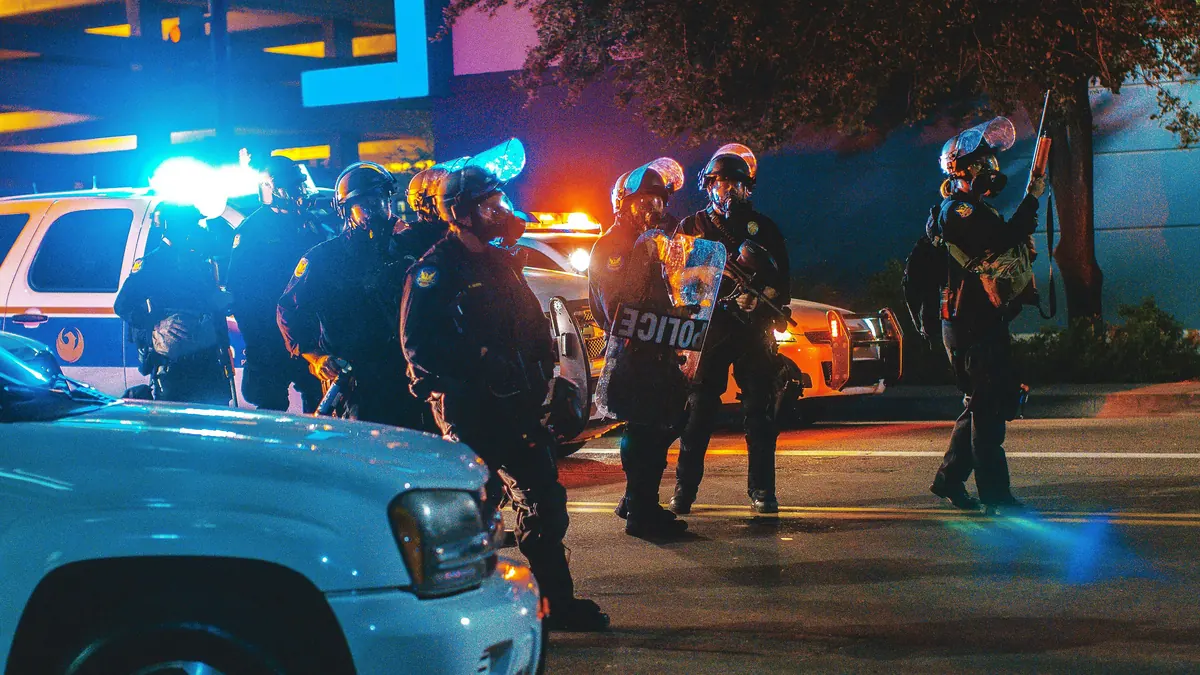 Agentes de policía junto a un vehículo policial durante una intervención nocturna en la vía pública